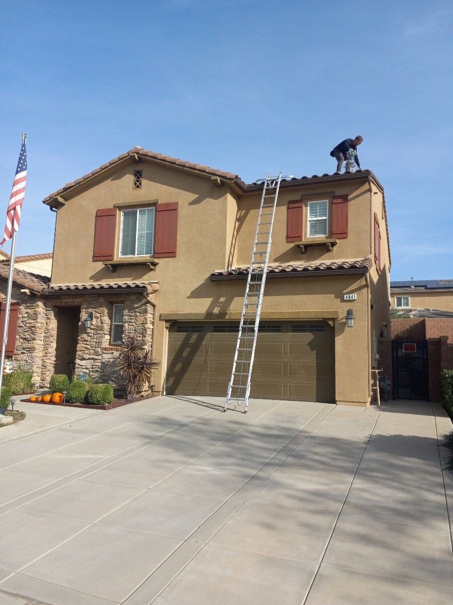Light Up Riverside team member installing lighting on a roofline