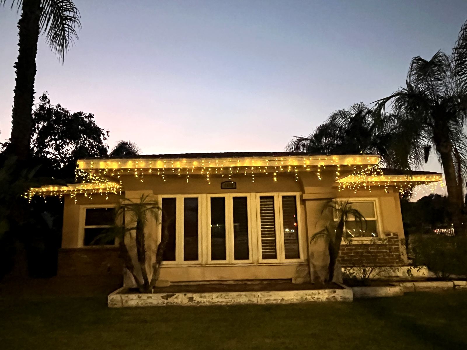 Commercial building roofline with icicle Christmas lights at dusk