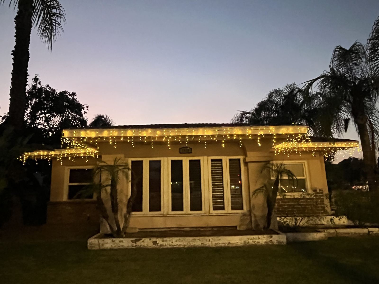 Ranch home with icicle lights at dusk