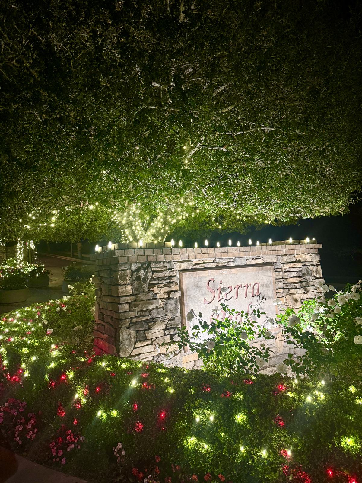 Close-up of the Sierra Peaks Community monument sign with Christmas lighting in Corona, CA