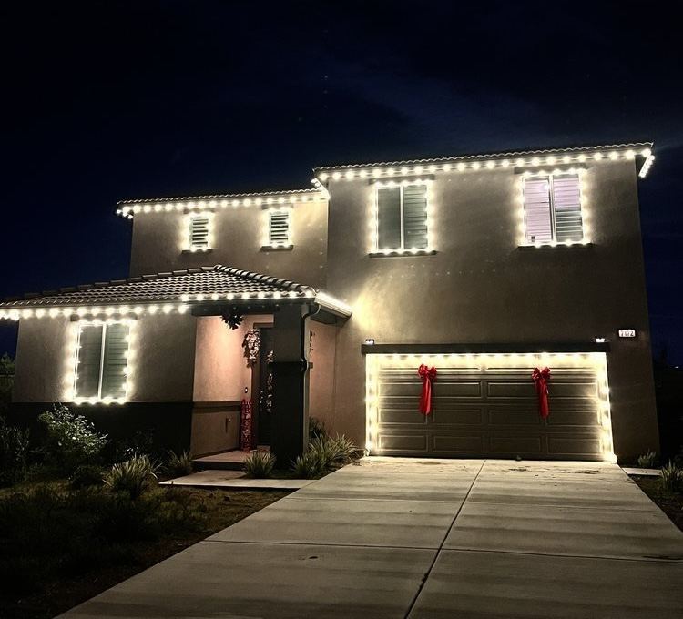 Two-story home with red bows on garage doors