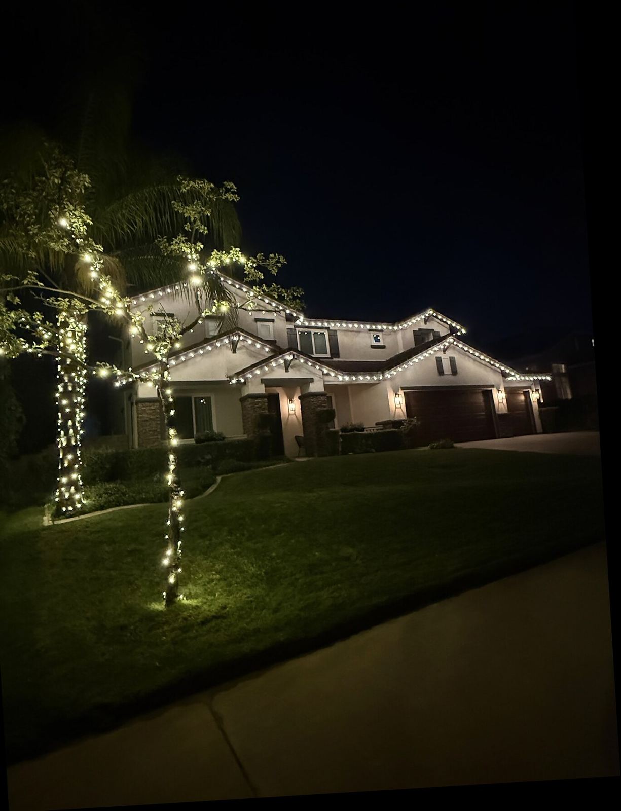 Two story warm white trees front yard night — Christmas light installation in Riverside, CA