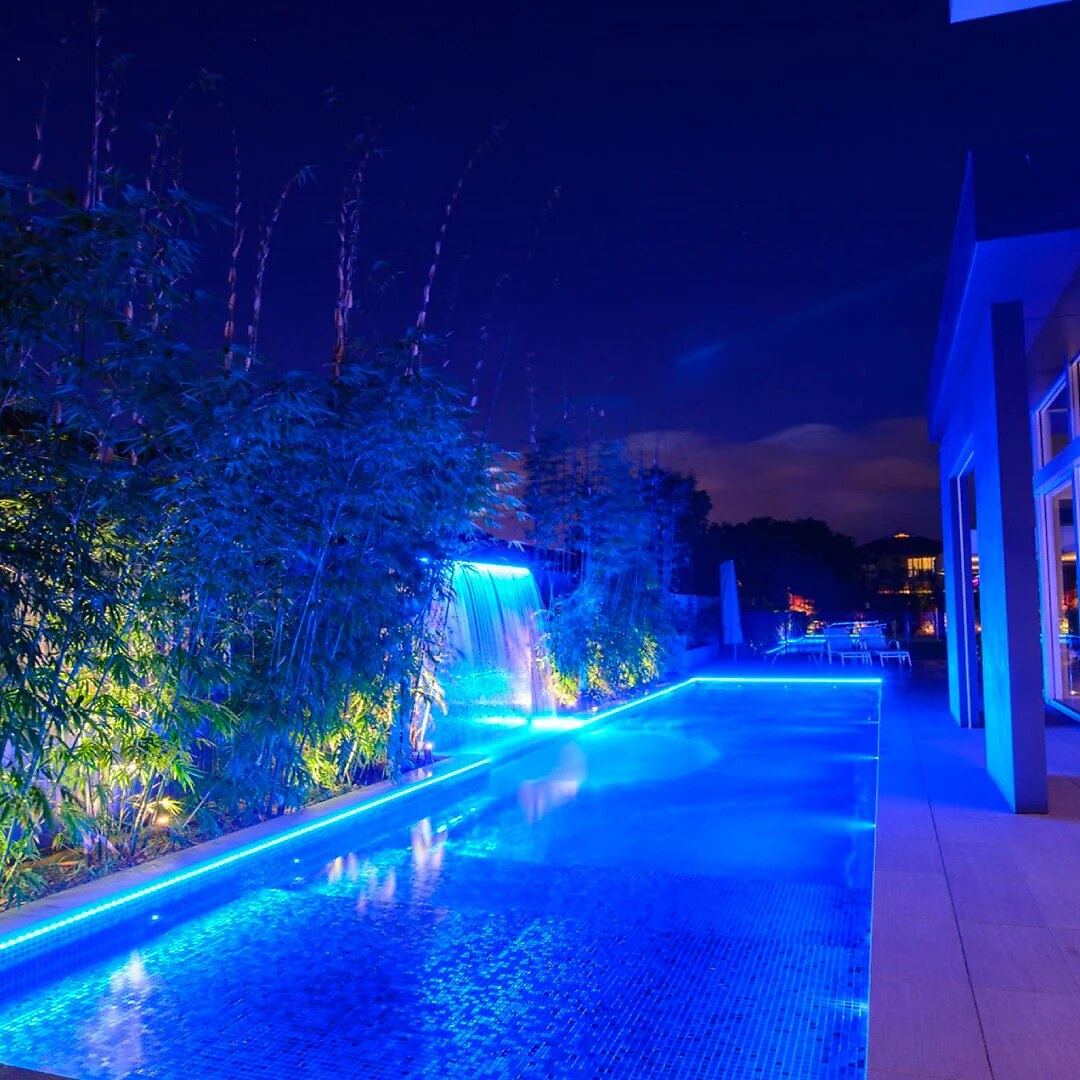 Modern pool waterfall blue night — landscape lighting install in Riverside, CA