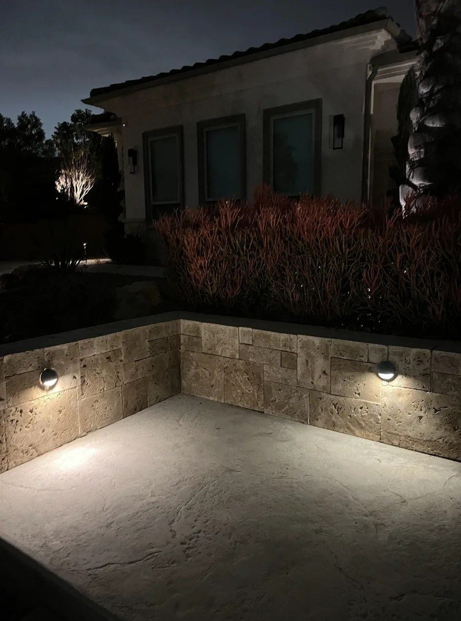 Stone wall sconce corner patio — landscape lighting install in Riverside, CA
