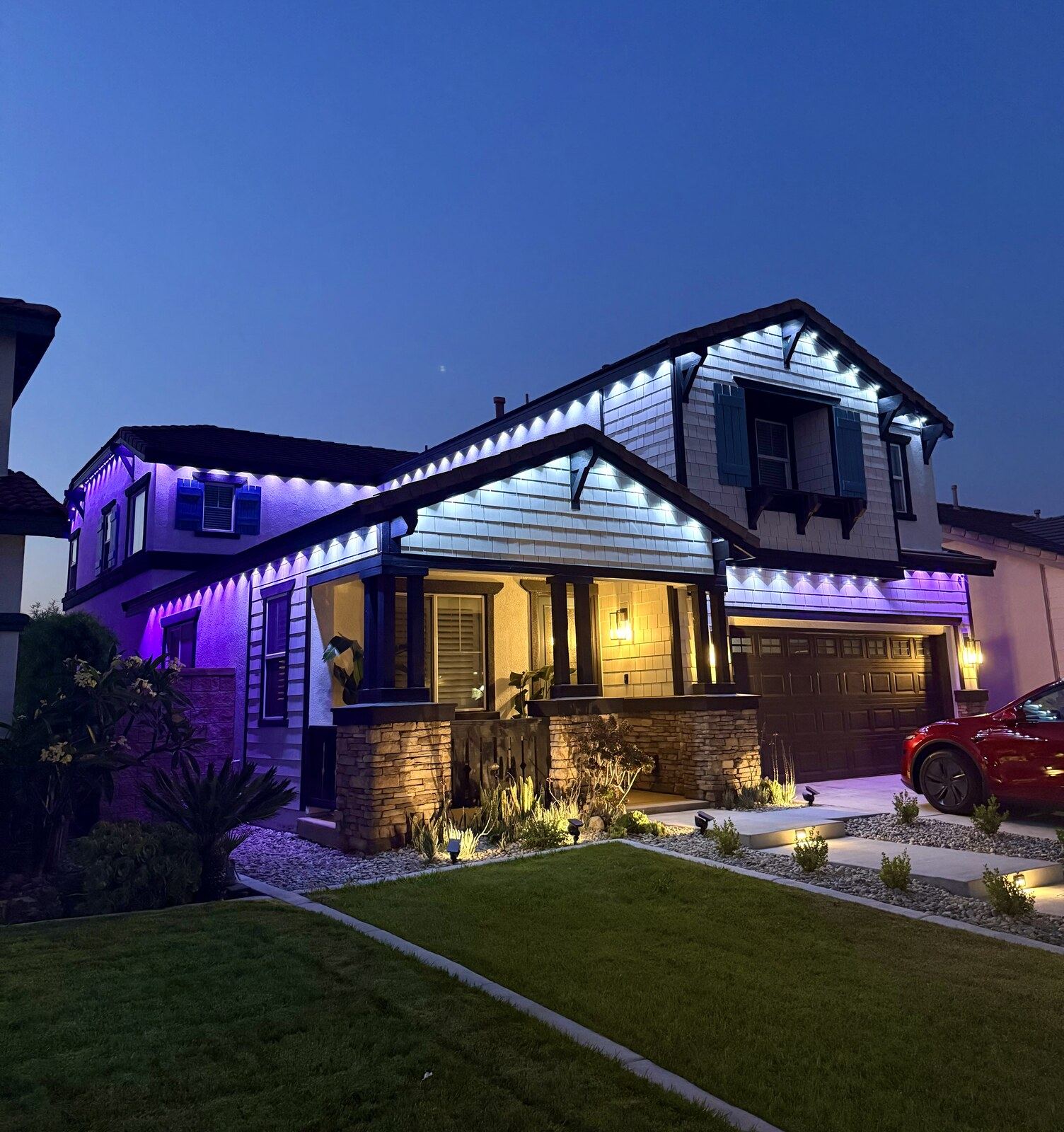 Permanent roofline LED lighting in white and purple on two-story craftsman home