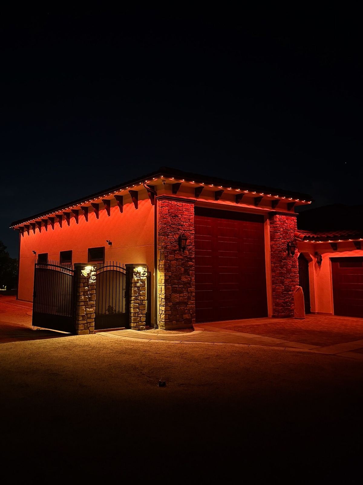 Garage red wash gate night — permanent LED roofline lighting in Riverside, CA