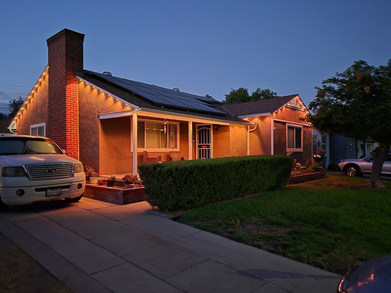 Ranch brick chimney warm white dusk — permanent LED roofline lighting in Riverside, CA