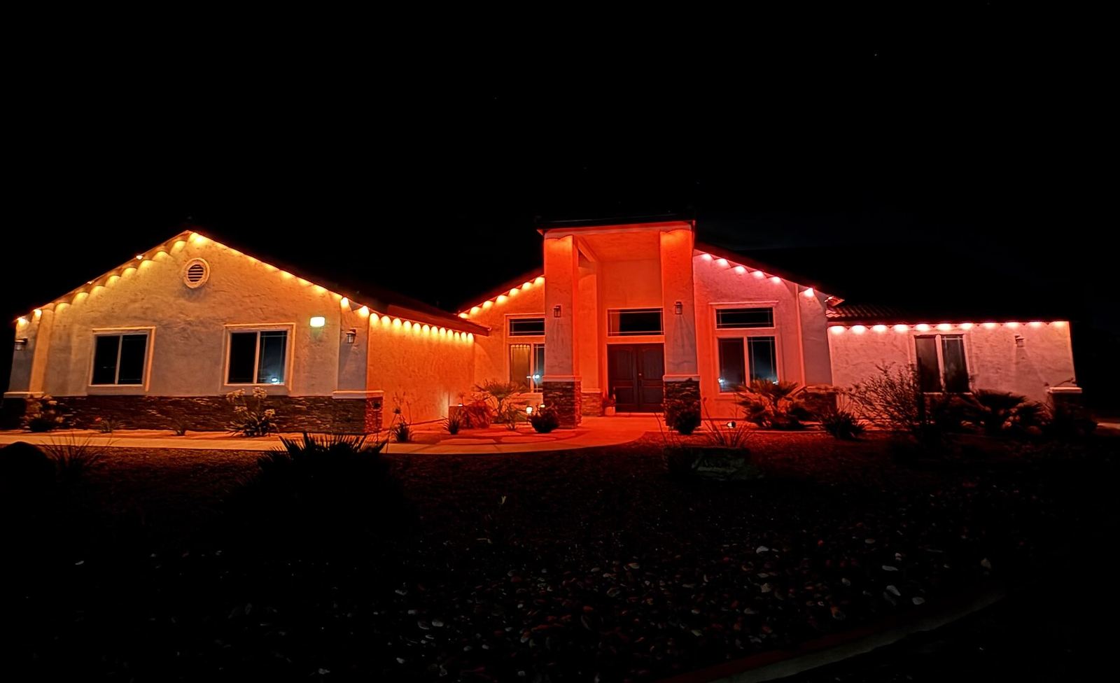 Single story orange red columns night — permanent LED roofline lighting in Riverside, CA