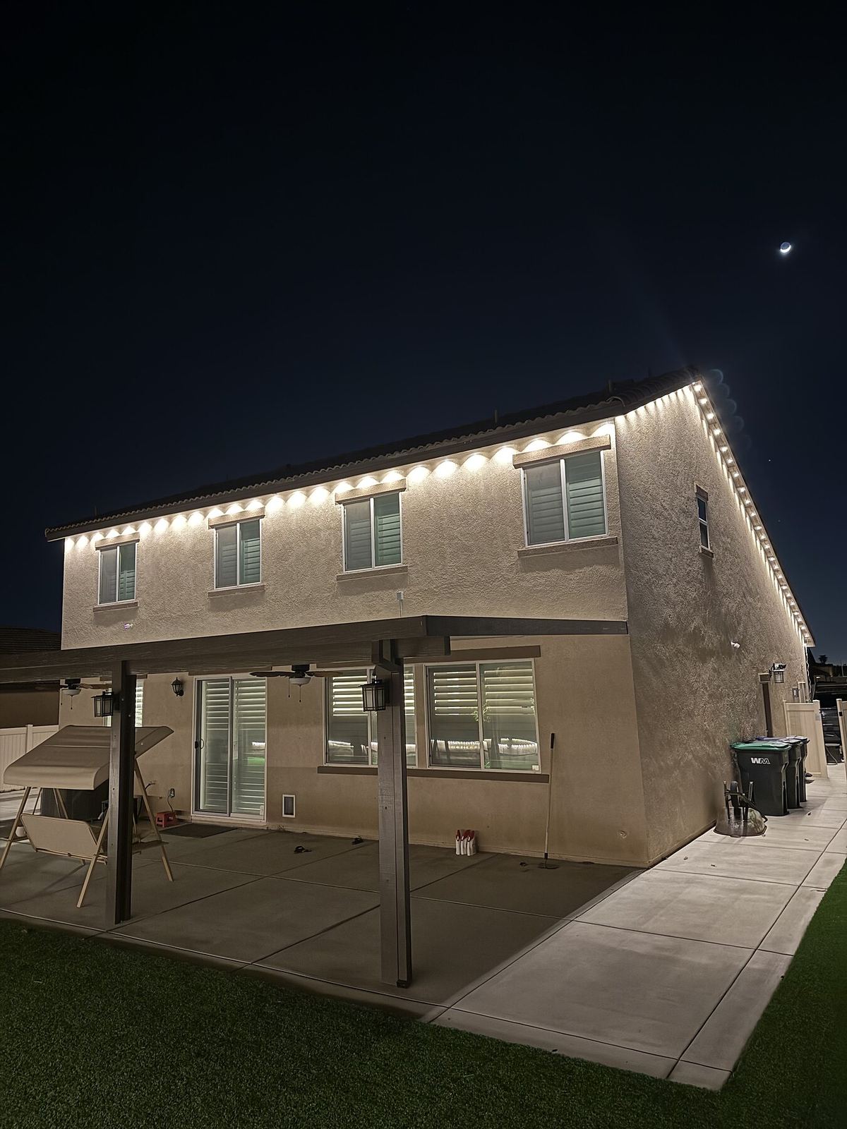 Two story blue purple palm night — permanent LED roofline lighting in Riverside, CA