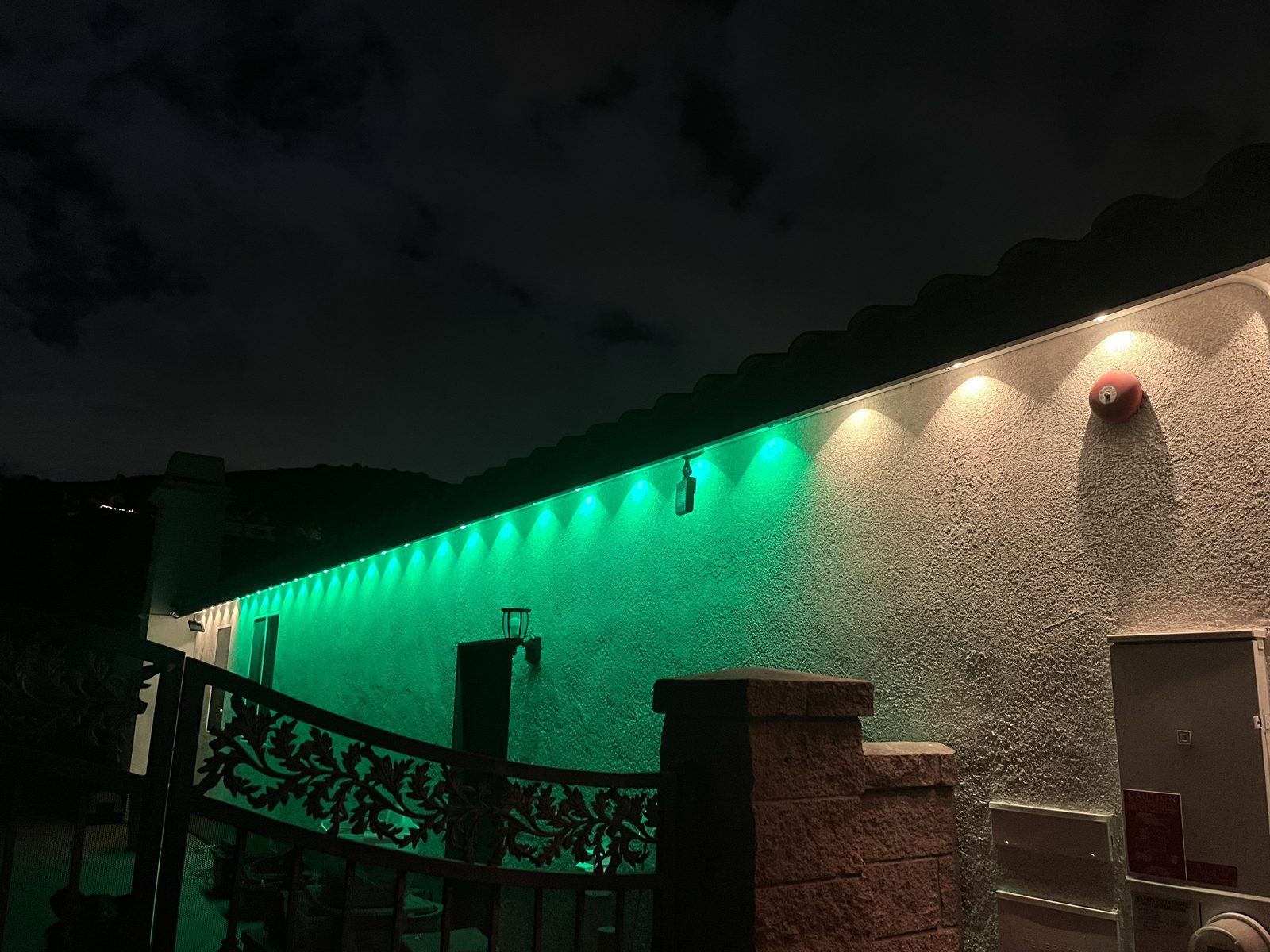 Permanent green and white roofline lighting at dusk