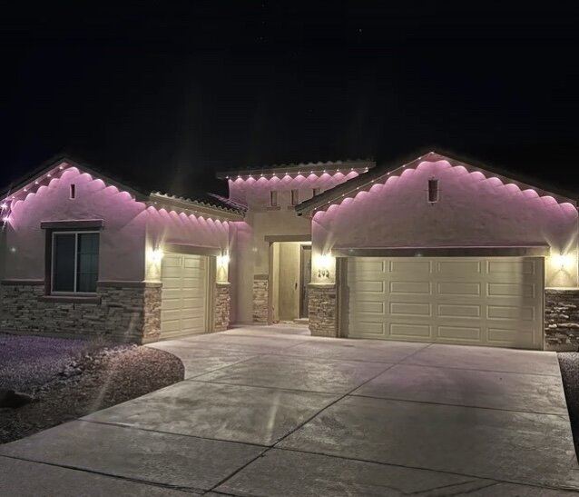 Permanent lighting in pink and lavender on ranch home roofline