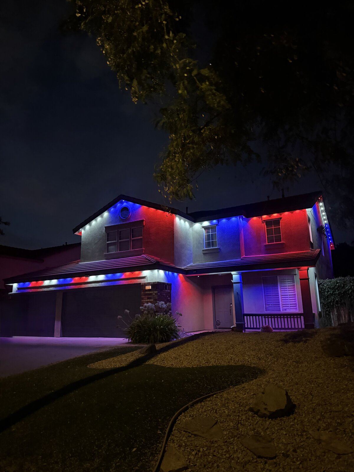 Permanent lighting in patriotic red, white, and blue on two-story home