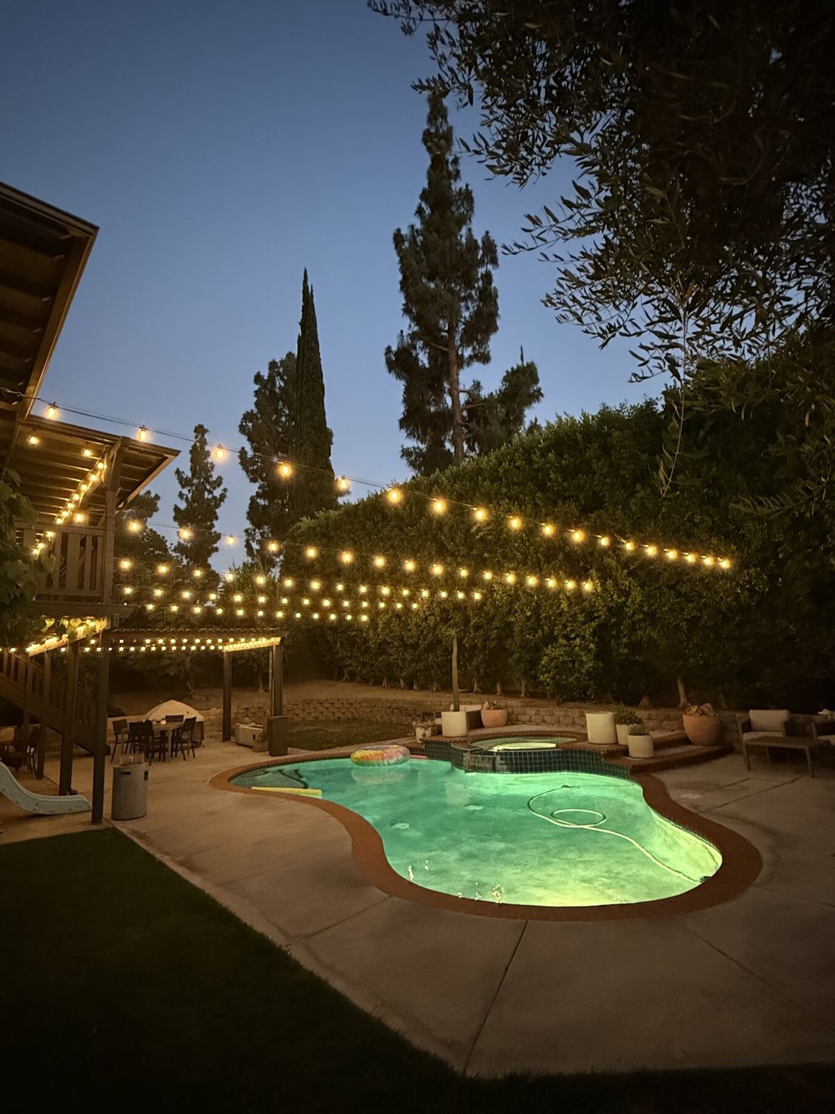 String lighting over curved pool patio at night
