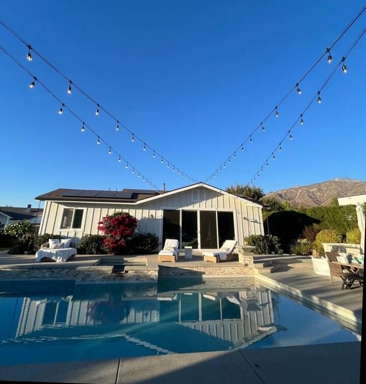 String lighting over pool in daytime with mountain view
