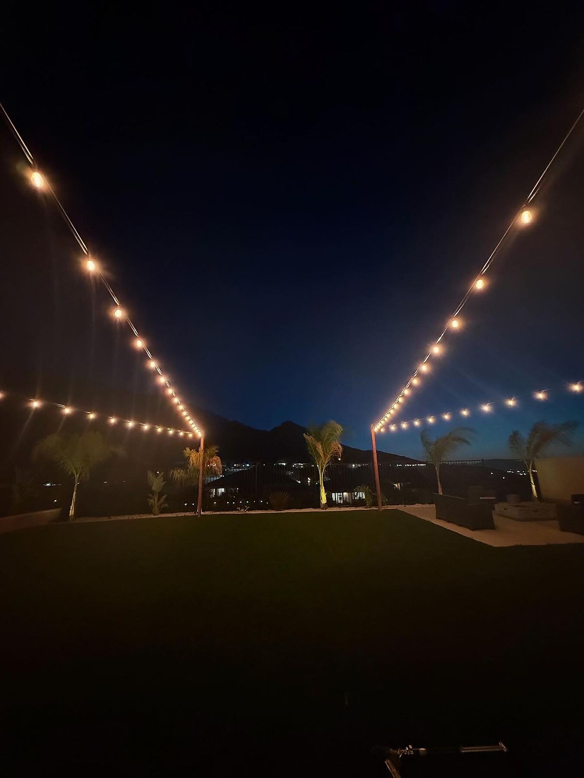 Backyard crossing poles dusk — bistro & string lighting install in Riverside, CA
