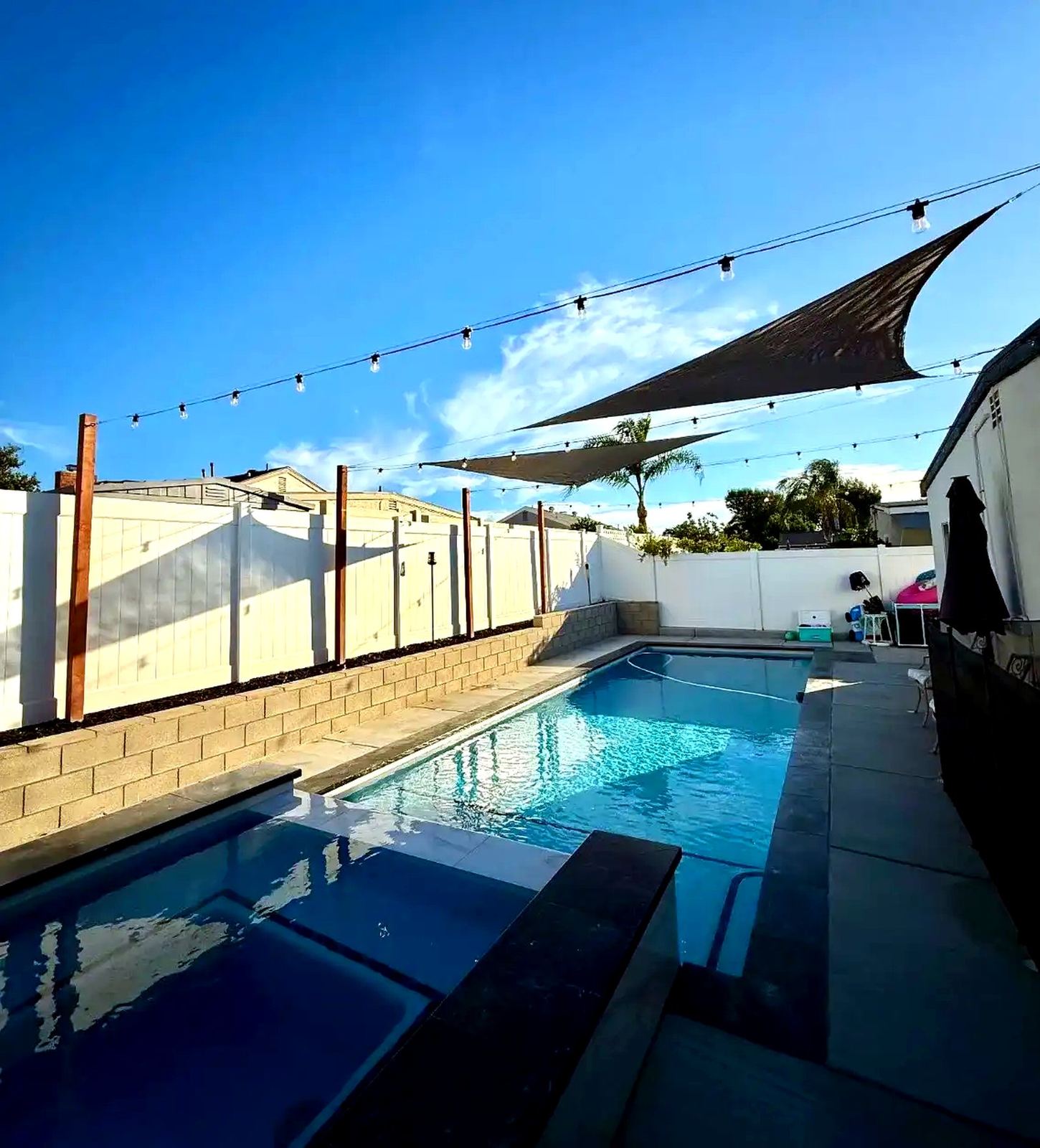 Dusk pool patio storm sky — bistro & string lighting install in Riverside, CA